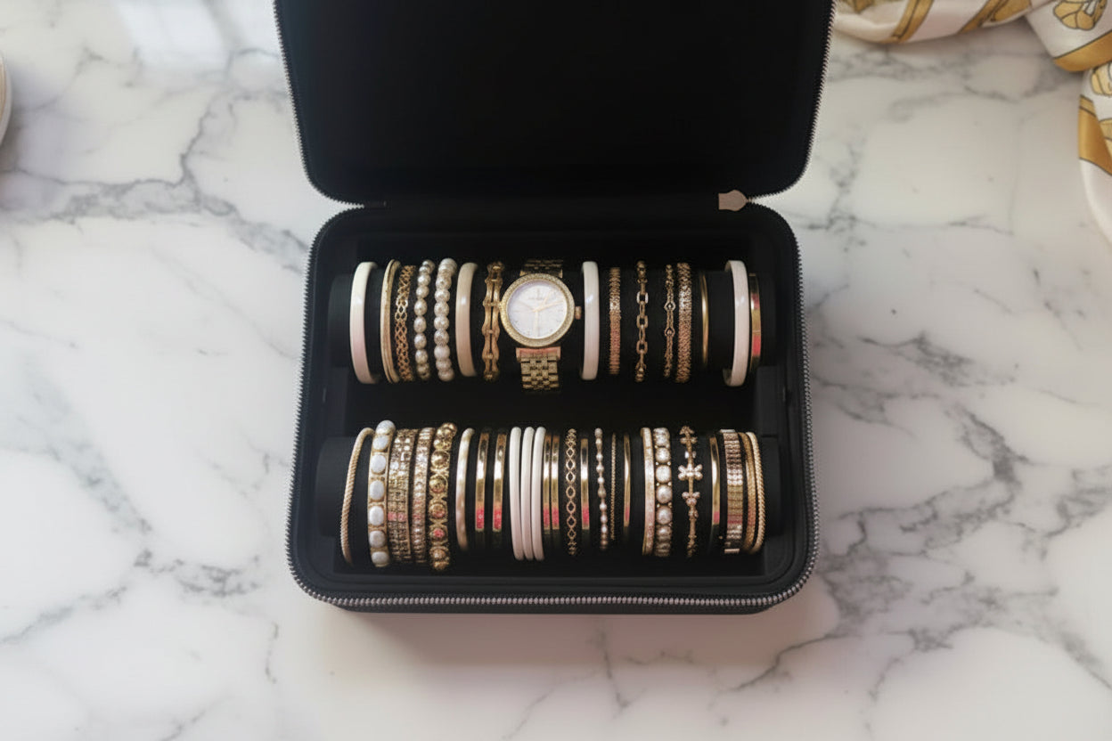 Set of bracelets in a black jewelry box on a marble surface, top view