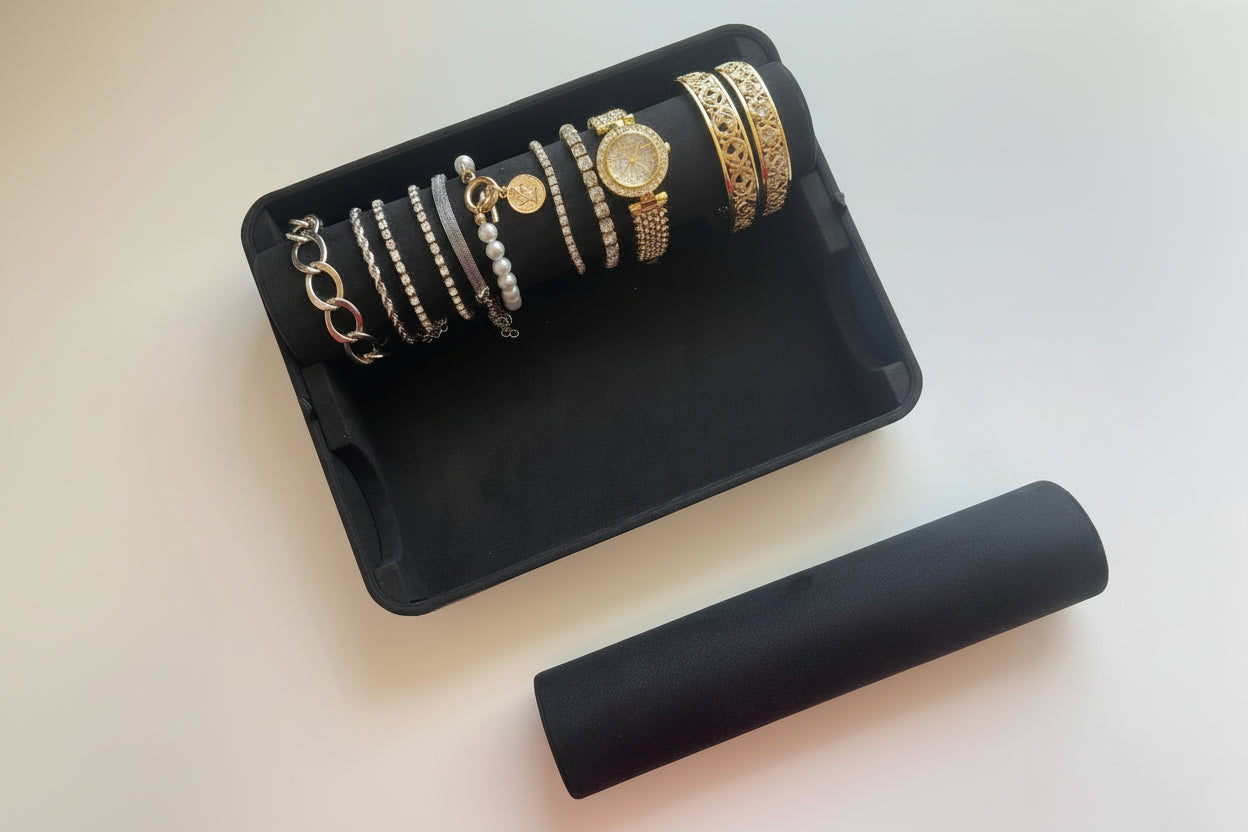 Jewelry organizer with two rods on a white surface, one rod holding multiple bracelets inside the container, the other rod on outside with no bracelets